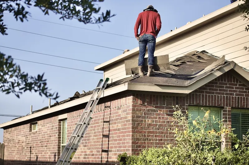 Professional roofer working on a residential roof in Linden Chapel Woods